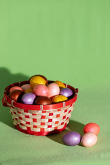 Easter eggs in basket isolated on green