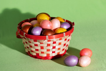 Easter eggs in basket isolated on green