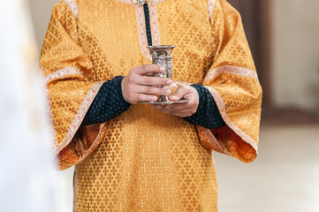 Silver chalice in the priests hand