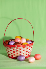 Easter eggs in basket isolated on green