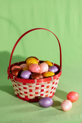 Easter eggs in basket isolated on green