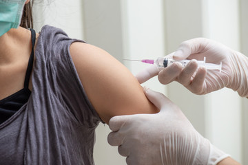 Asian women come to receive vaccinations to prevent disease.