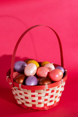 Easter eggs in basket isolated on red