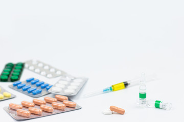 Medicine pills or capsules with syringe on white background.