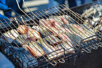 Pieces of fish on the grill. The fish is laid out on a grid and grilled on charcoal. Carnival celebration. Treats for the festive table. Bilogorodka. Ukraine. Shrovetide, February 25, 2017