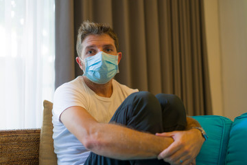 covid-19 virus lockdown - sad and worried man in medical mask thinking and feeling scared in...