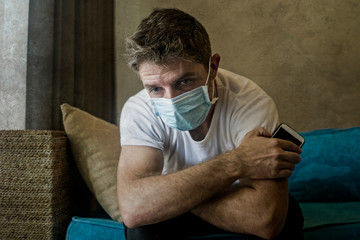 covid-19 virus lockdown - sad and worried man in medical mask thinking and feeling scared in...