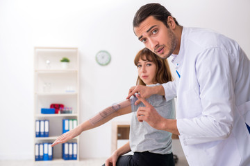 Young male doctor checking woman joint flexibility