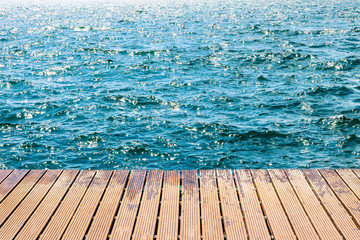 Sea waves with wooden planks dock.