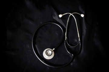 The stethoscope put on black canvas,grunge surface background