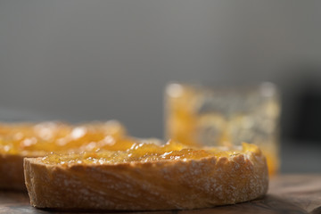 Ciabatta slices with orange marmalade on olive board