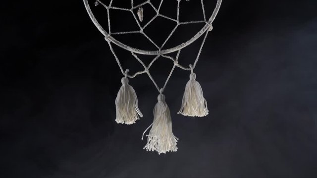 Mystical attribute dreamcatcher on a black background with smoke