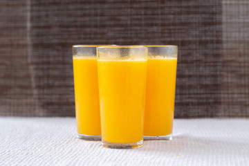 Orange juice in a glass with orange decoration, the best start to the day. Photo on a dark background.