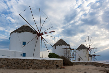 The ancient windmills of the island of Mykonos with a cloudy sky in the background