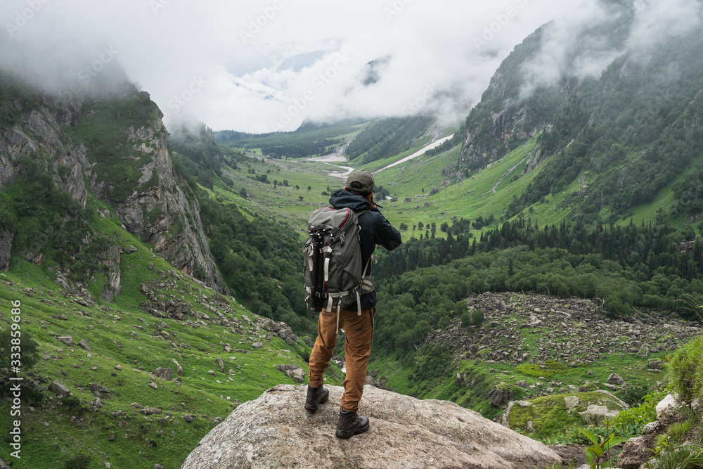 Wall mural Photographer taking picture of mountain valley in summer season, Pin Bhaba pass trek in Shimla, north India