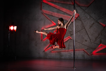Obraz premium Beautiful girl dancing on the pole at studio