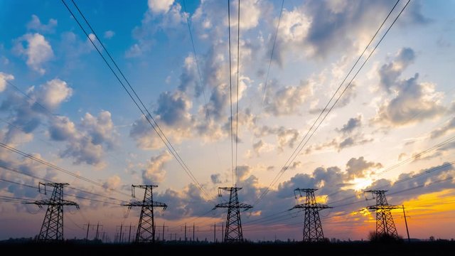 Time Lapse of Electrical Grid and Transmission Line at Sunset. Electricity Pylons Against Sky During Sunset. Clouds Moving Across Sky. Landscape of Five High Voltage Towers. 4K UHD ProRes 422 (HQ)