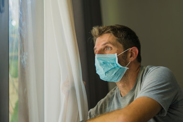 covid-19 virus lockdown - sad and worried man in medical mask thinking and feeling scared in...
