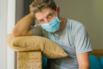 covid-19 virus lockdown - sad and worried man in medical mask thinking and feeling scared in...