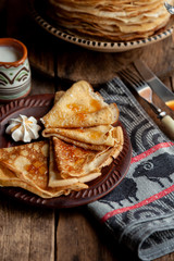 A stack of thin pancakes on a plate. Homemade pastries. Pancakes for breakfast. Appetizing food. Thin pancakes on a plate. Homemade crepes, tasty food. Staple of yeast pancakes.