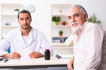 Old man visiting young male doctor cardiologist