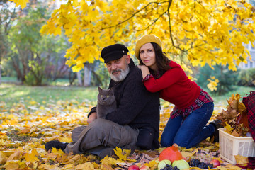 Woman with man and cat in autumn park