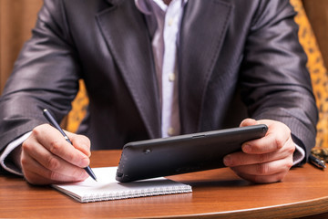 Businessman with tablet computer sitting at table