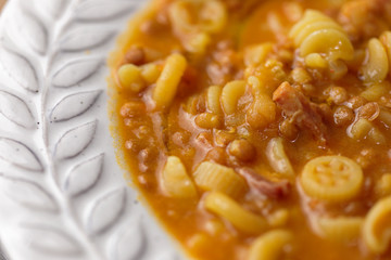 Lentils and mix pasta soup close up.