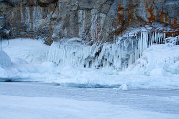 Fototapeta na wymiar Rock cliff with ice stalactite in Lake Baikal, Russia, landscape photography