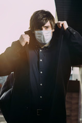 Asian guy in a medical mask in the city. coronavirus. viros protection. Disease epidemic