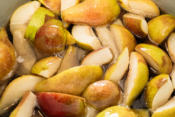 Sliced sweet pears in a quarter are cooked with sugar to prepare the filling for the pie or canning...