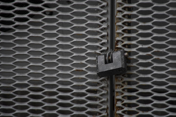 Fototapeta na wymiar mesh fence lock old gray metal closed