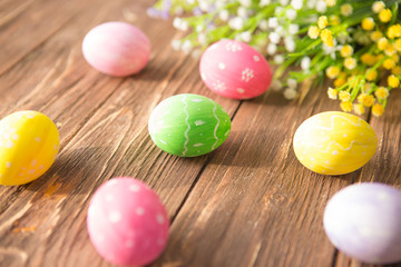 Fototapeta na wymiar Colorful easter eggs with flowers on a old wooden surface