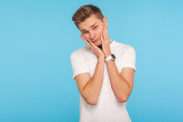 Portrait of lazy depressed young man in casual white t-shirt leaning on hands with bored tedious...