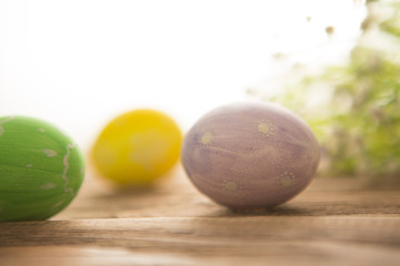 Colorful easter eggs with flowers on a old wooden surface