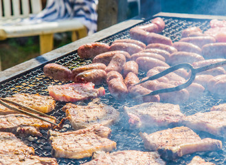 sausages and pork steaks on the large barbeque