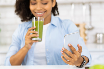 Black Woman Drinking Smoothie And Using Phone