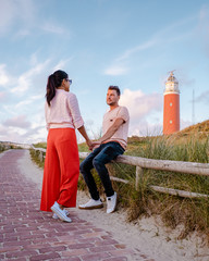 Texel lighthouse during sunset Netherlands Dutch Island Texel, couple visit the lighthouse , men...
