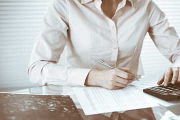 Bookkeeper woman or financial inspector making report, calculating or checking balance, close-up....