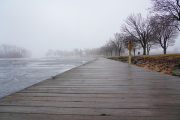 Fototapeta premium Quiet community park covered in dense fog during cold winter to spring season day