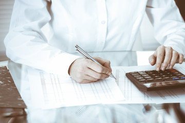 Bookkeeper woman or financial inspector making report, calculating or checking balance, close-up....