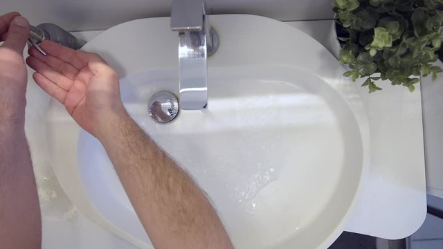 Lavaggio accurato delle mani nel lavandino di casa strofinando bene anche le dita
