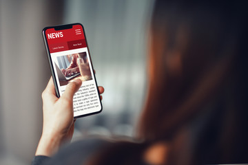 Online news on a smartphone. Mockup website. Woman reading news or articles in a mobile phone...