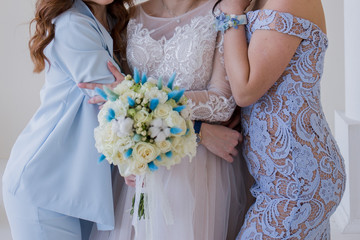 bride with bridesmaids and a bouquet in the room