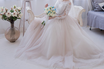 bride with a bouquet sits in a chair