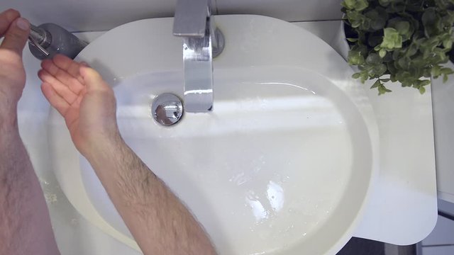 Lavaggio accurato delle mani nel lavandino di casa strofinando bene anche le dita