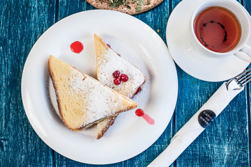 Two sweet sandwiches with tea on the blue wooden table