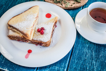 Two sweet sandwiches with tea on the blue wooden table