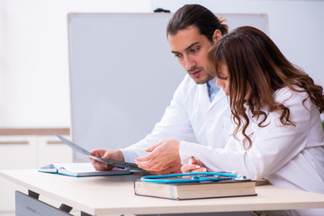 Young male doctor radiologist and female student in the classroo