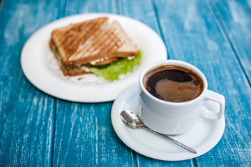 Breakfast with a cup of coffee and two toasted sandwiches